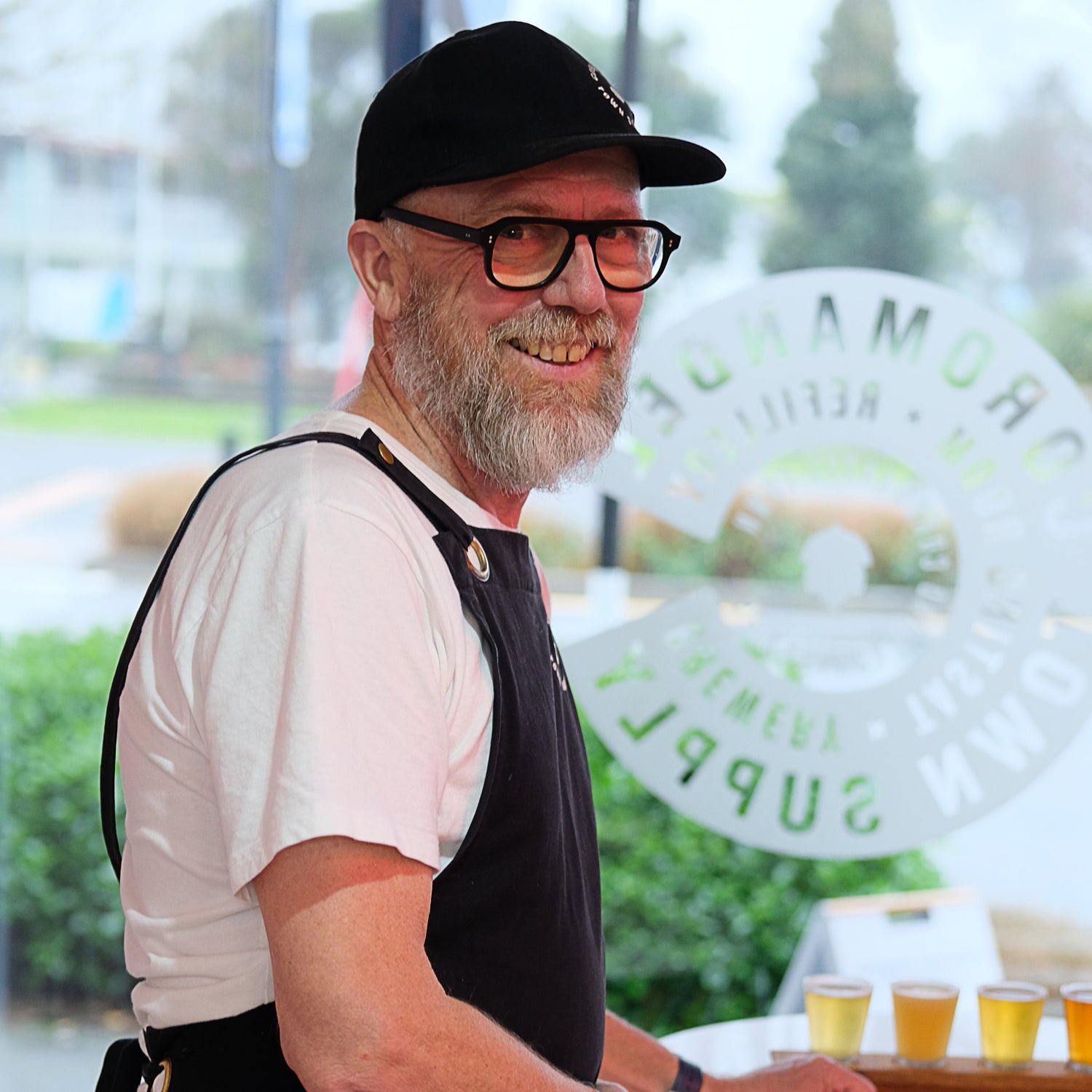Tony Blackett at The Coromandel Town Supply sitting at a bar with drinks in the background.